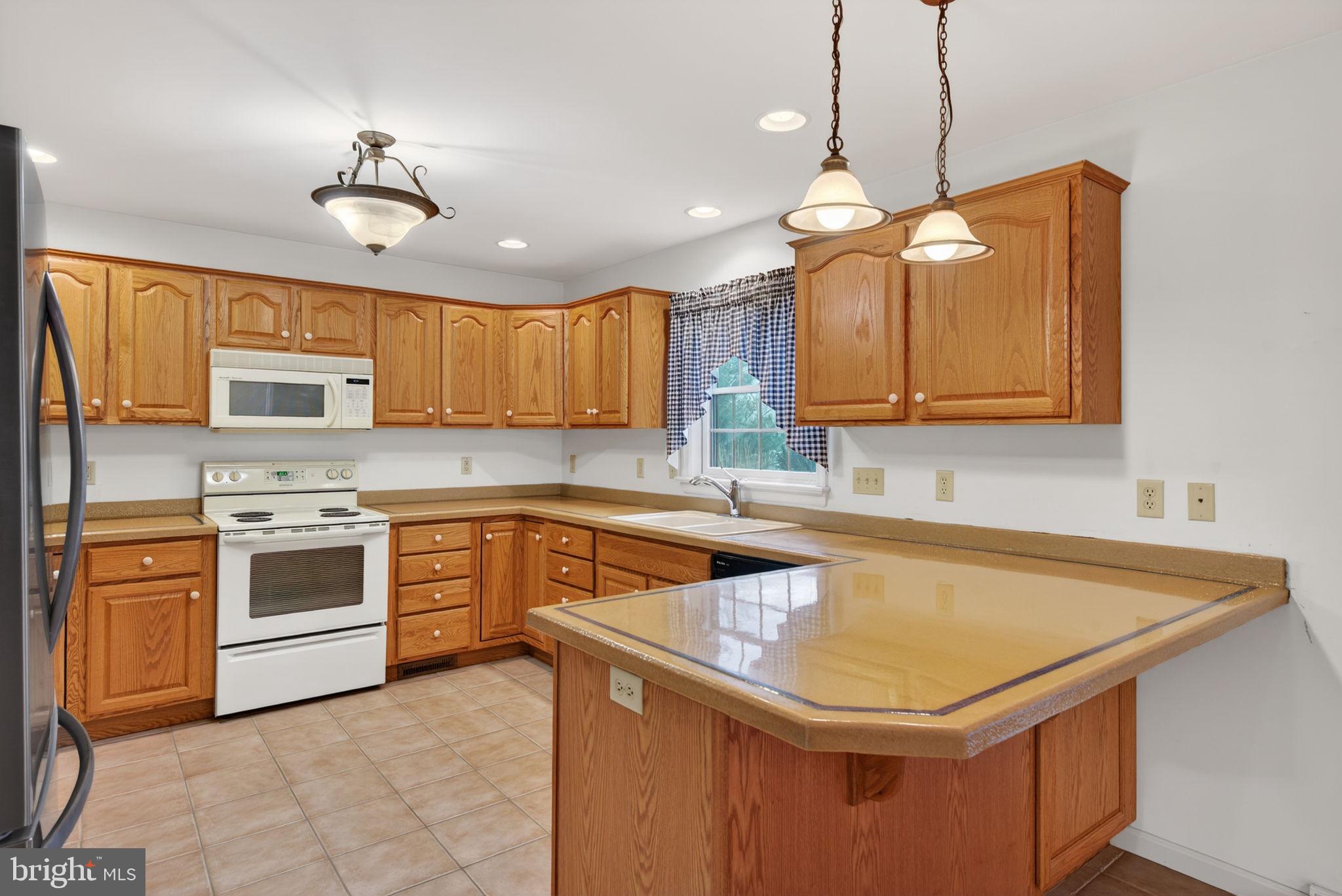 817 Aarons Lane Manheim, PA 17545 - Photo 21 of 64 a kitchen with stainless steel appliances granite countertop a sink a stove a refrigerator cabinets and wooden floor