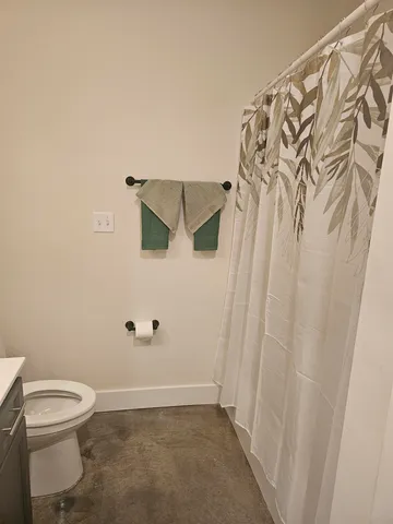 a bathroom with a toilet and a shower curtain