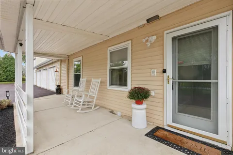 a view of a patio with table and chairs and a barbeque