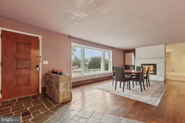 a dining room with furniture and a floor to ceiling window
