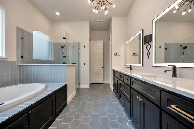 a spacious bathroom with a double vanity sink a large mirror and a shower