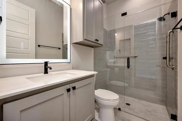 a bathroom with a sink a toilet and shower