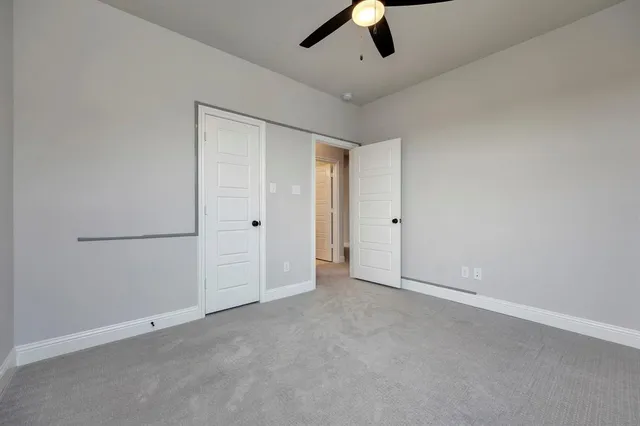 an empty room with chandelier fan