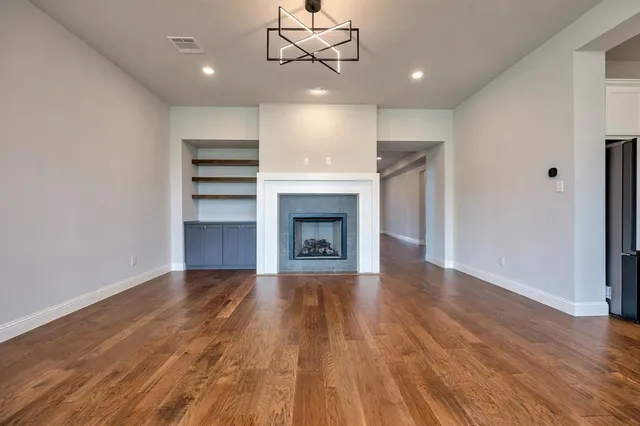 a view of an empty room with a fireplace and a window