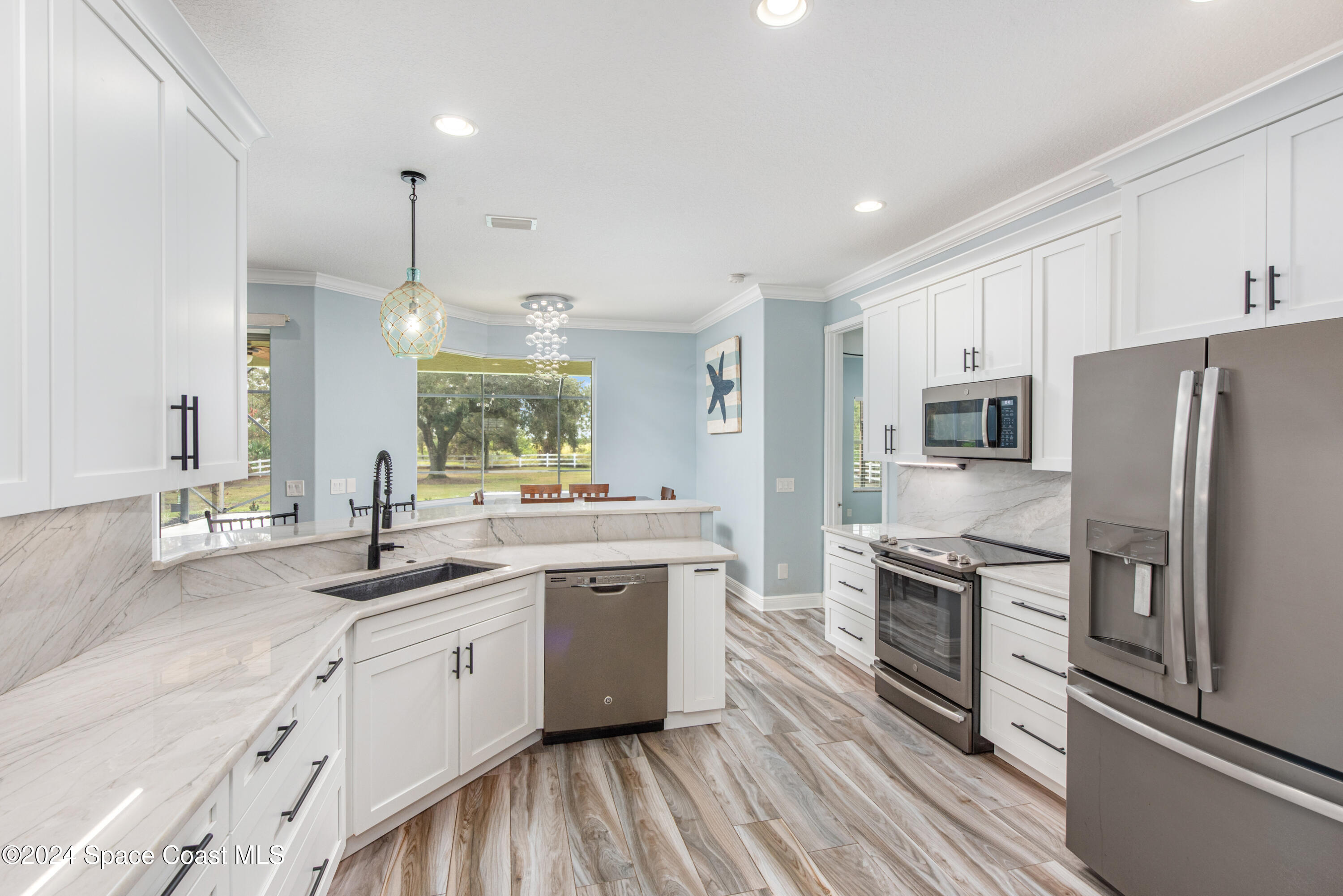 4153 Red Bay Street Grant, FL 32949 - Photo 25 of 63 a kitchen with stainless steel appliances granite countertop a sink stove and refrigerator