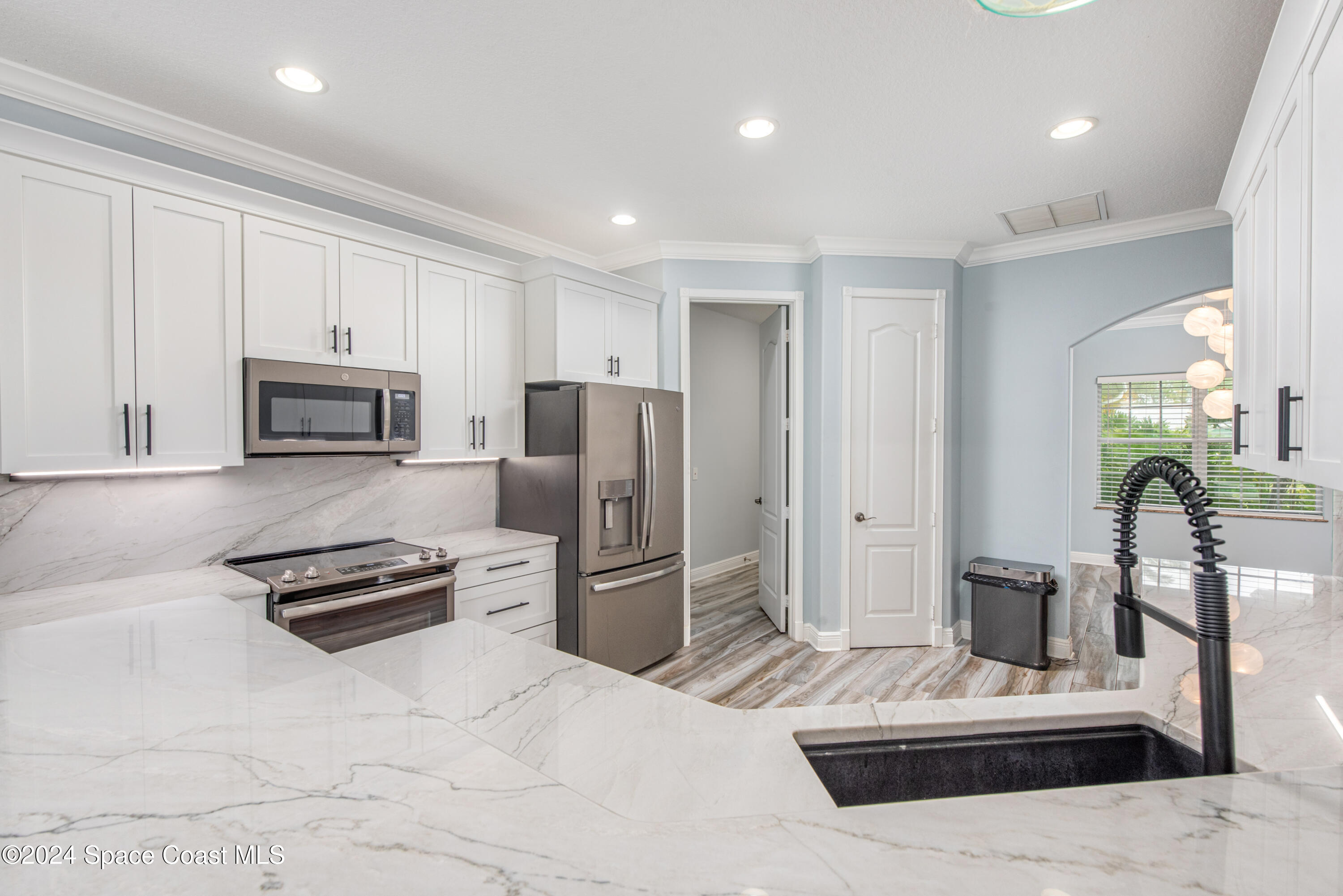 4153 Red Bay Street Grant, FL 32949 - Photo 27 of 63 a kitchen with stainless steel appliances kitchen island granite countertop a refrigerator and a stove top oven