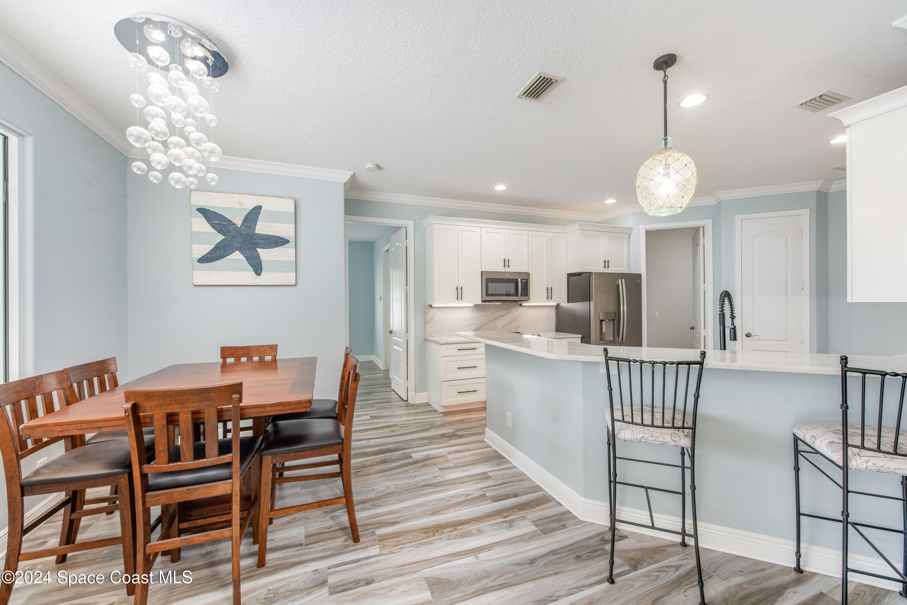 4153 Red Bay Street Grant, FL 32949 - Photo 30 of 63 a view of a dining room with furniture wooden floor and chandelier