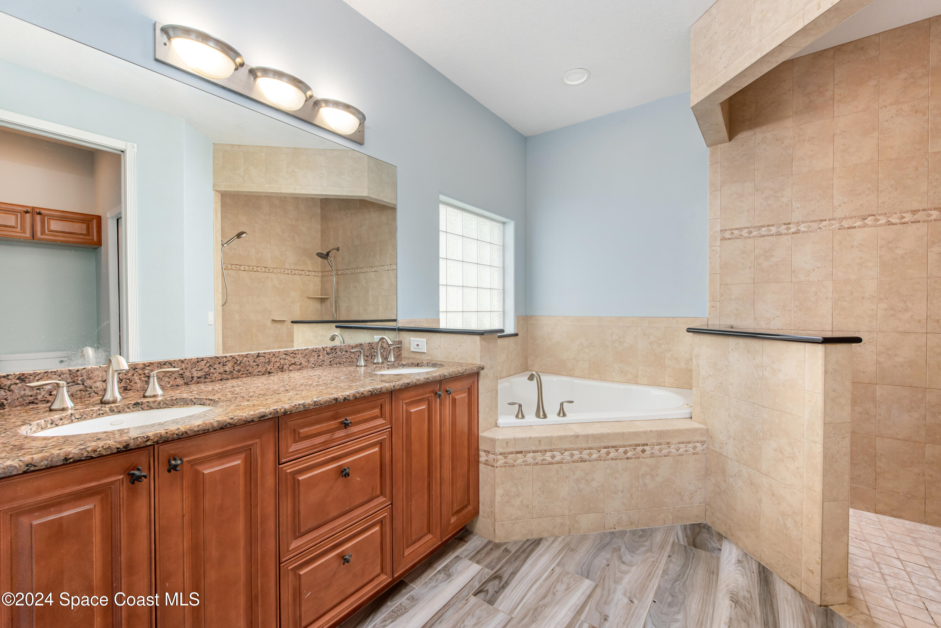4153 Red Bay Street Grant, FL 32949 - Photo 39 of 63 a bathroom with a granite countertop sink a large mirror and a bathtub