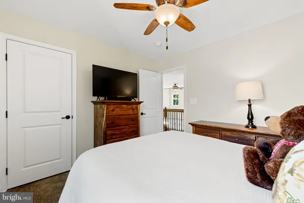 a bedroom with a bed and a flat tv screen on dresser