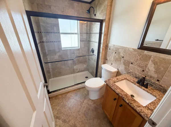 a bathroom with a bathtub shower sink vanity and toilet