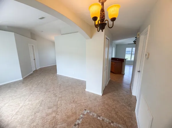 an empty room with windows and wooden floor