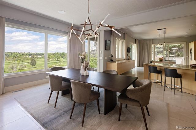 a view of a dining room and livingroom with furniture wooden floor a chandelier