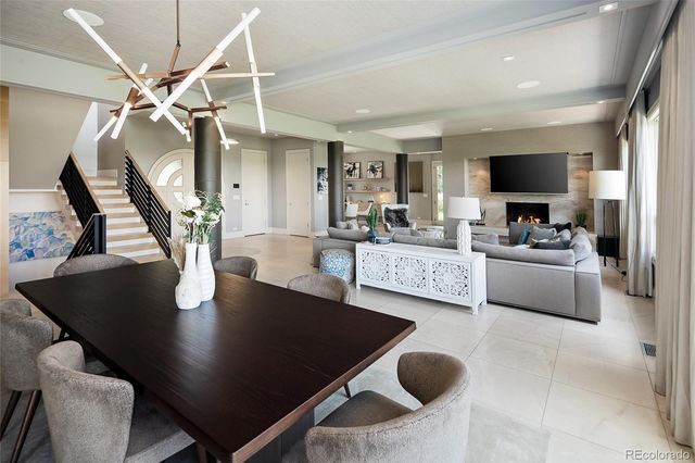 a living room with dining table and a floor to ceiling window
