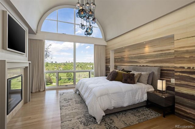 a bedroom with a large bed a flat tv screen and a dresser