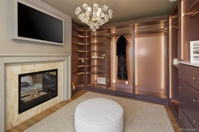 a living room with a fireplace a flat screen tv and a walk in closet