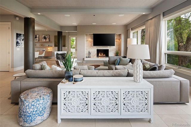 a living room with furniture a flat screen tv and a large window