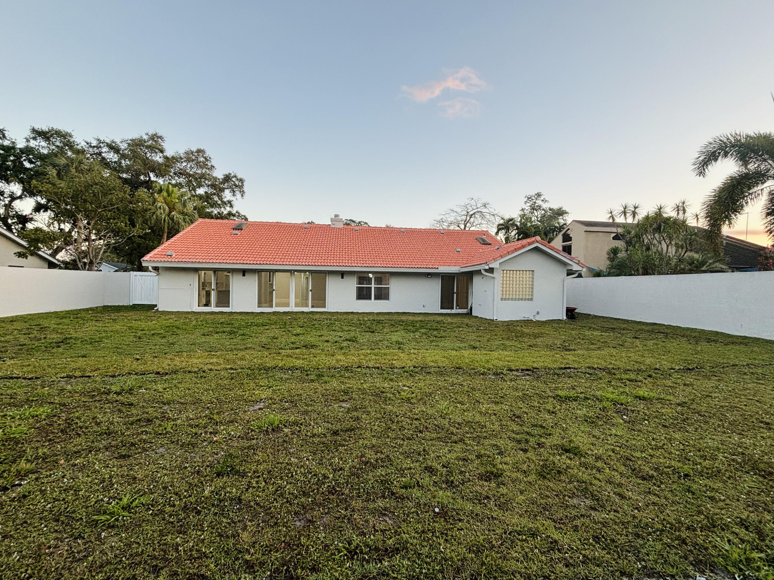 1341 West Royal Palm Road Boca Raton, FL 33486 - Photo 3 of 19 a front view of a house with garden
