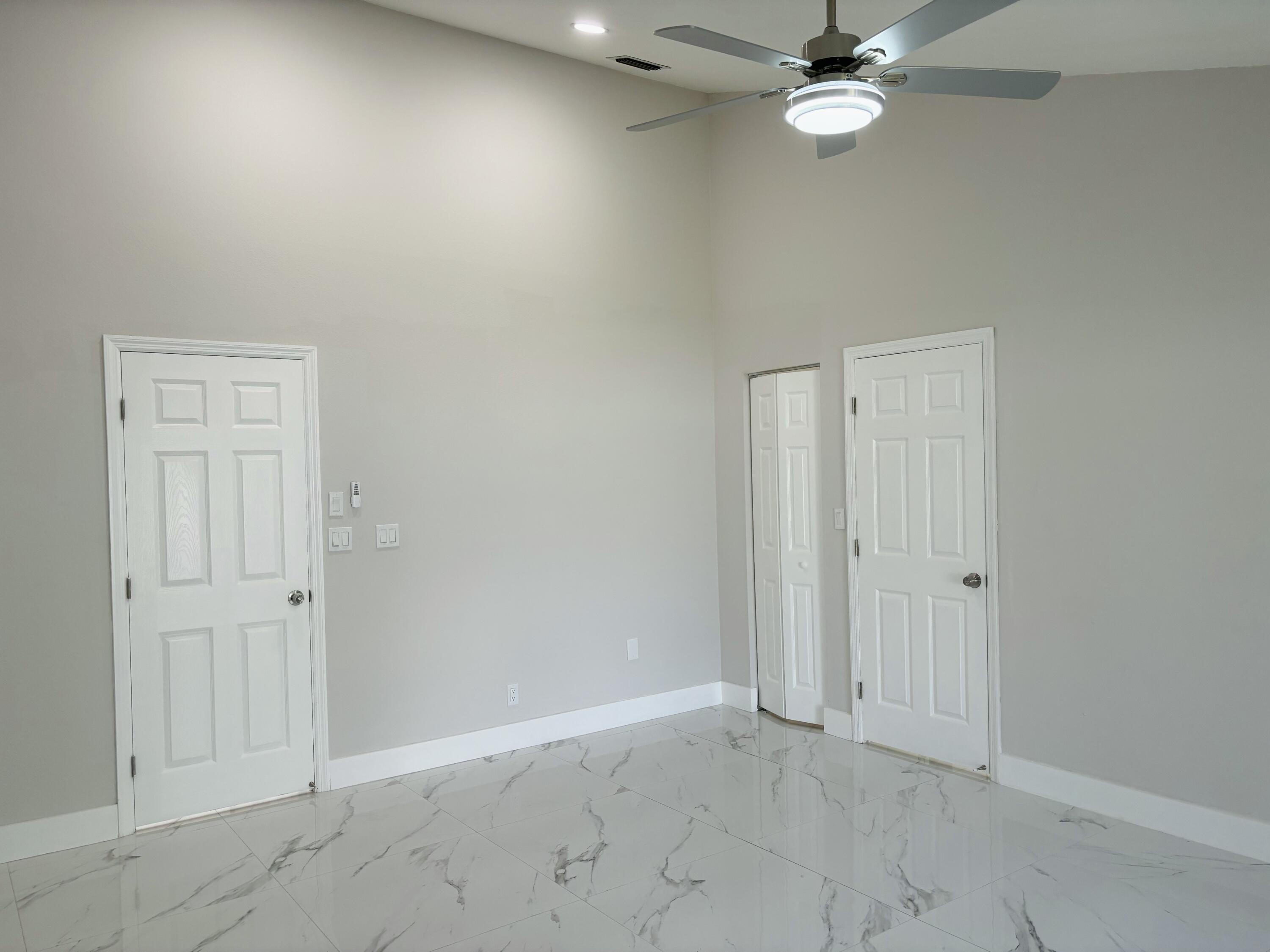 1341 West Royal Palm Road Boca Raton, FL 33486 - Photo 9 of 19 an empty room with a chandelier fan and closet area