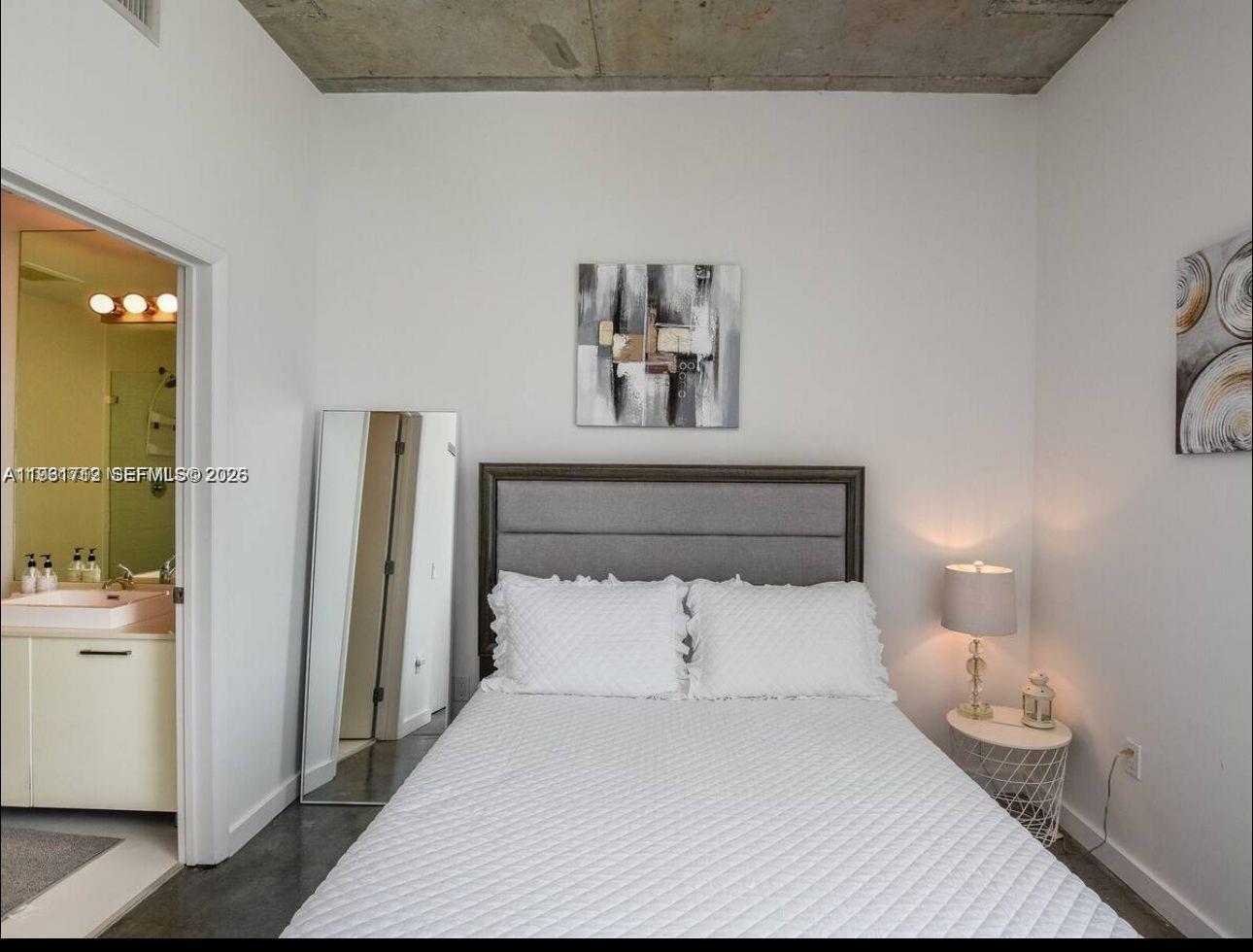 151 Southeast 1st Street, Unit 2104 Miami, FL 33131 - Photo 18 of 29 a bedroom with a bed and a night stand