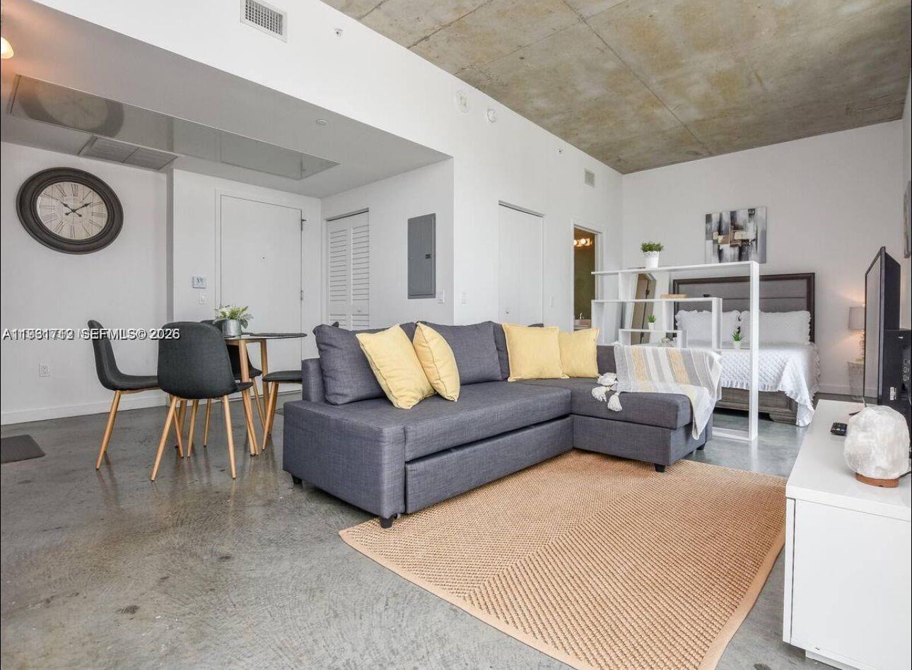 151 Southeast 1st Street, Unit 2104 Miami, FL 33131 - Photo 19 of 29 a living room with furniture and a clock
