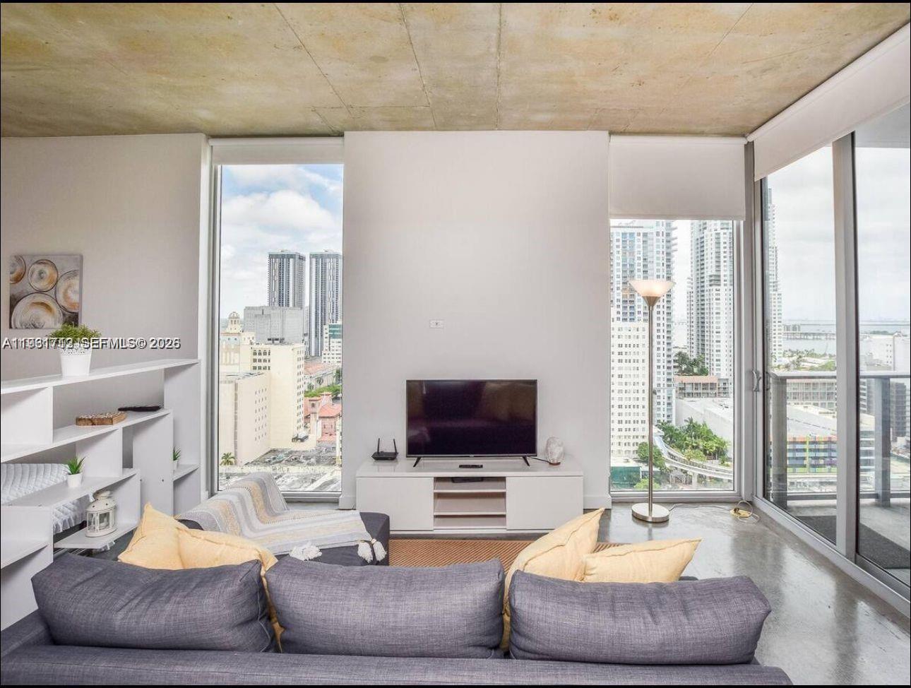 151 Southeast 1st Street, Unit 2104 Miami, FL 33131 - Photo 23 of 29 a living room with furniture and a flat screen tv