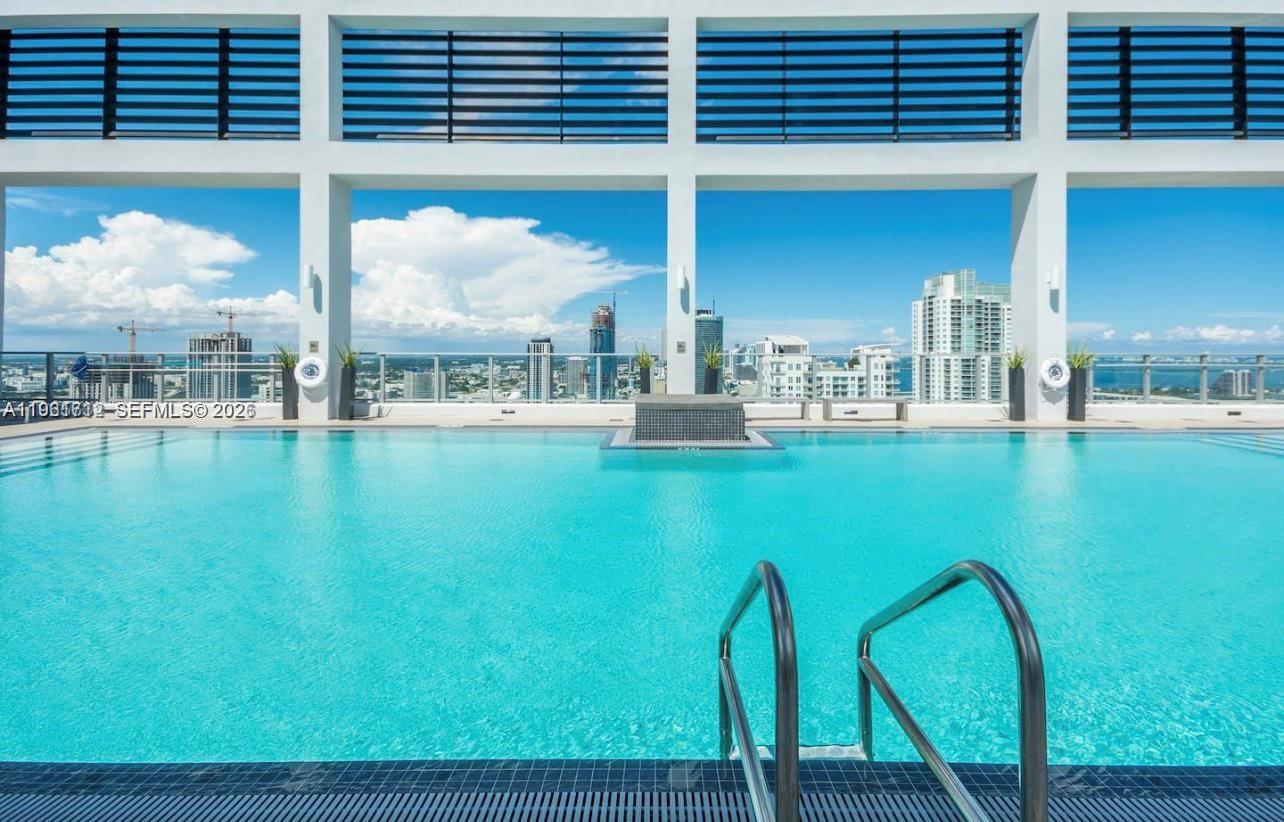 151 Southeast 1st Street, Unit 2104 Miami, FL 33131 - Photo 27 of 29 a kitchen with dining table and chairs