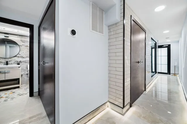 a view of hallway with walk in closet and wooden floor