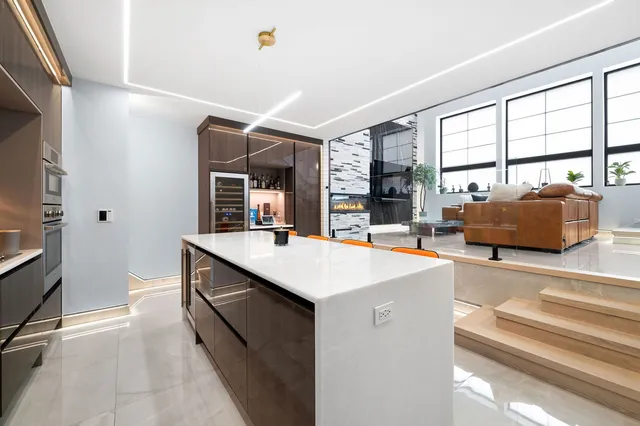 a kitchen with kitchen island granite countertop a sink and a stove top oven