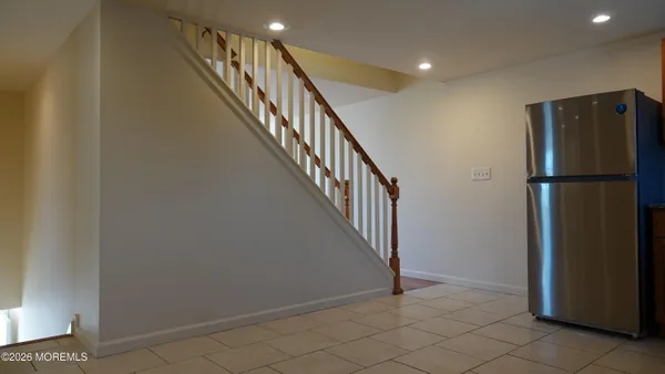 a view of staircase with lots of frames on wall and a window