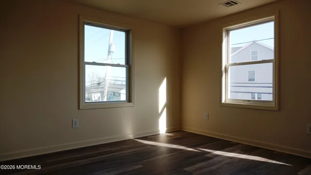 a view of an empty room with wooden floor