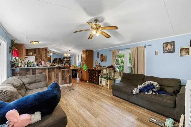 a living room with furniture kitchen view and a chandelier