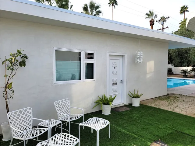 a view of a patio with table and chairs potted plants