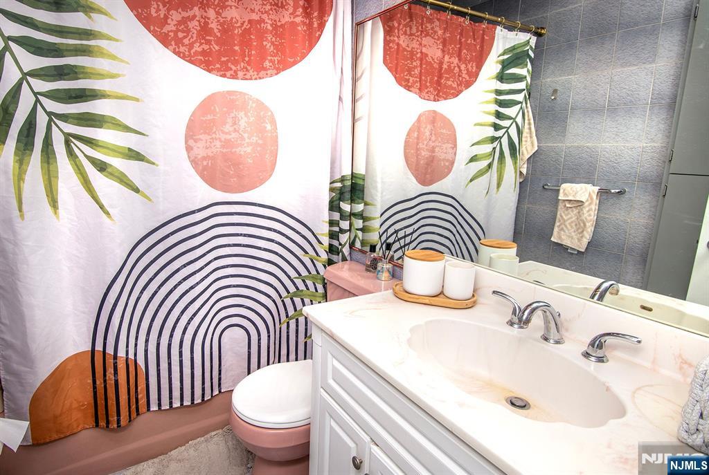 96 Porter Avenue Bergenfield, NJ 07621 - Photo 11 of 18 a bathroom with a sink a toilet and a mirror