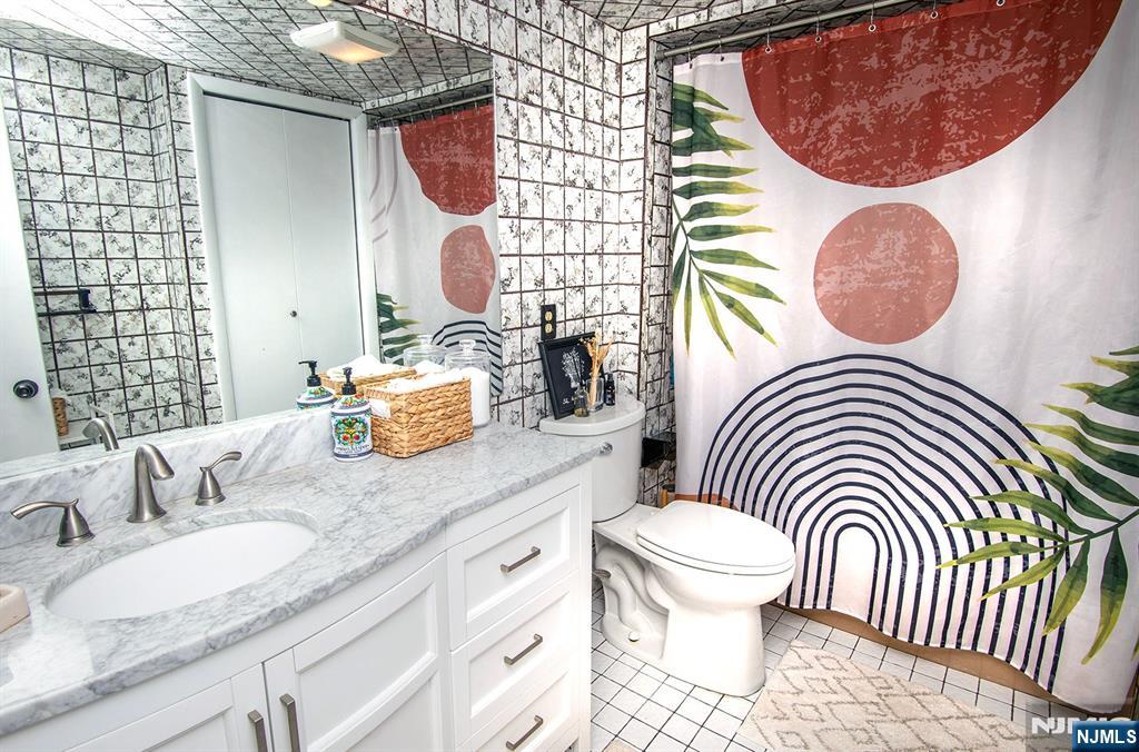 96 Porter Avenue Bergenfield, NJ 07621 - Photo 12 of 18 a bathroom with a granite countertop toilet and a mirror