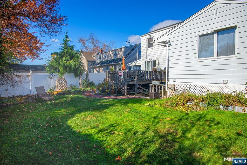 96 Porter Avenue Bergenfield, NJ 07621 - Photo 18 of 18 a backyard of a house with table and chairs plants and large tree