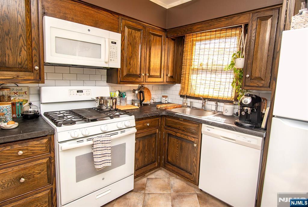 96 Porter Avenue Bergenfield, NJ 07621 - Photo 5 of 18 a kitchen with a stove a sink and a microwave