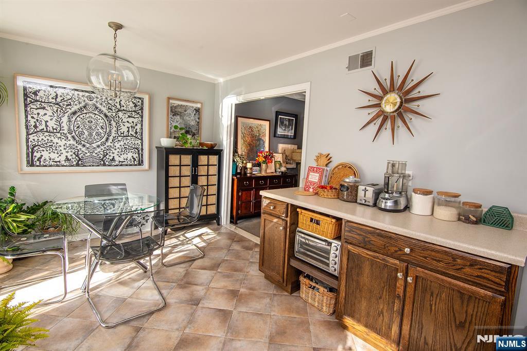 96 Porter Avenue Bergenfield, NJ 07621 - Photo 6 of 18 a kitchen with stainless steel appliances a table and chairs in it