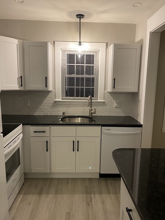 91 Main, Unit 2W Easton, MA 02356 - Photo 4 of 10 a kitchen with granite countertop a sink and a stove