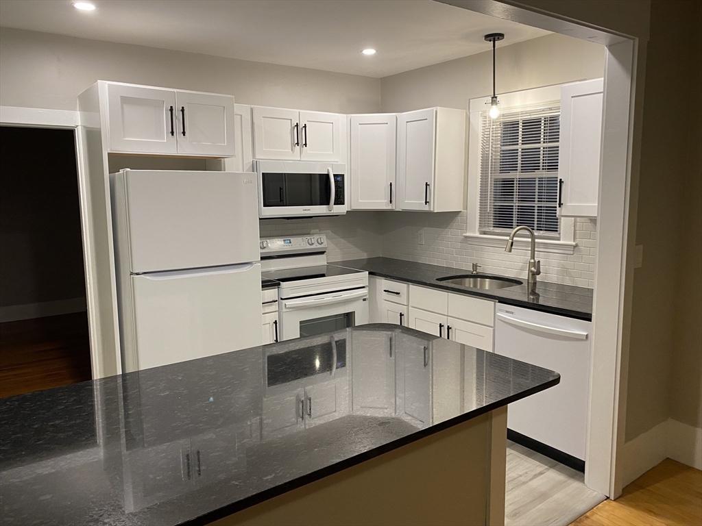 91 Main, Unit 2W Easton, MA 02356 - Photo 5 of 10 a kitchen with stainless steel appliances a refrigerator sink and microwave