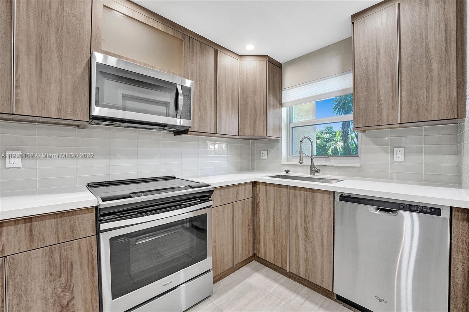 a kitchen with granite countertop cabinets stainless steel appliances and wooden floor