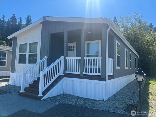a view of a house with wooden deck and a floor to ceiling window