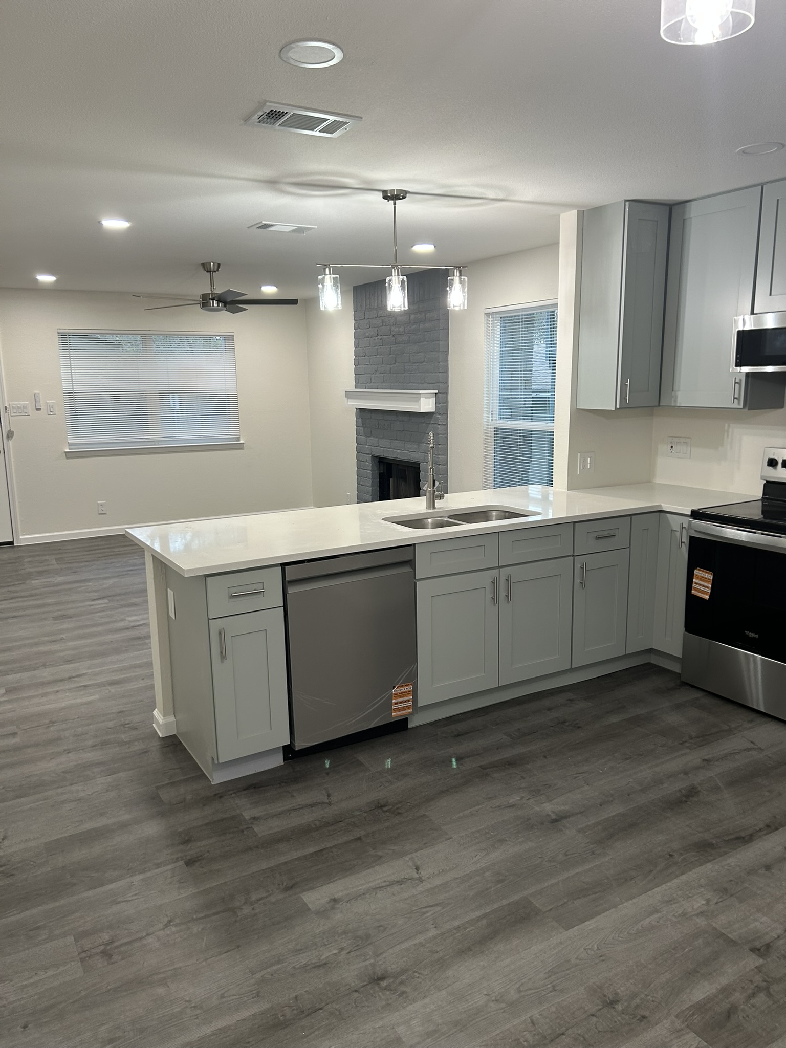 1507 Cinnamon Path, Unit A Austin, TX 78704 - Photo 3 of 8 a large white kitchen with kitchen island a sink dishwasher a stove and a refrigerator with wooden floor