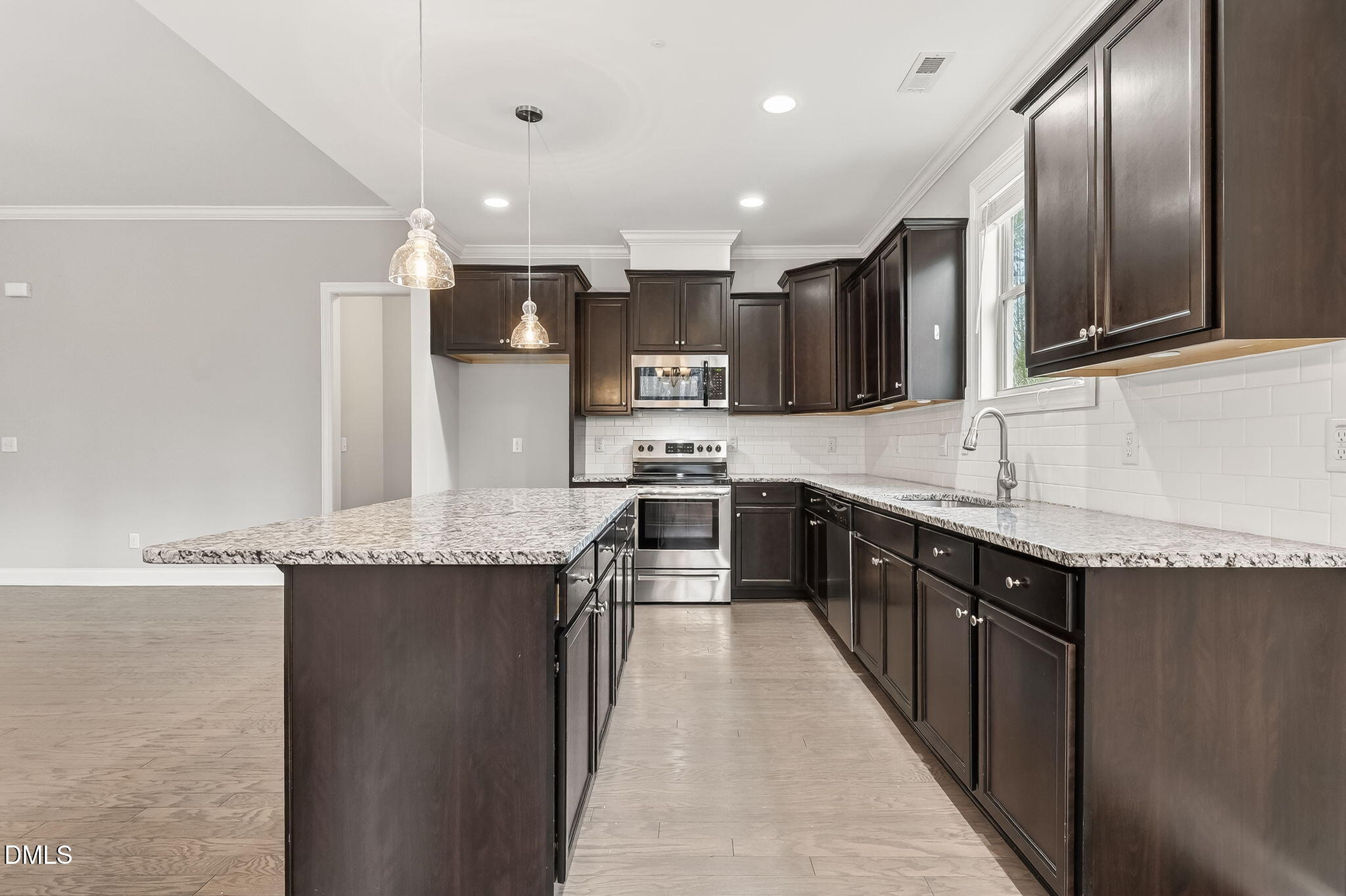5441 Fantasy Moth Drive Garner, NC 27529 - Photo 13 of 55 a large kitchen with stainless steel appliances kitchen island granite countertop a stove and a sink