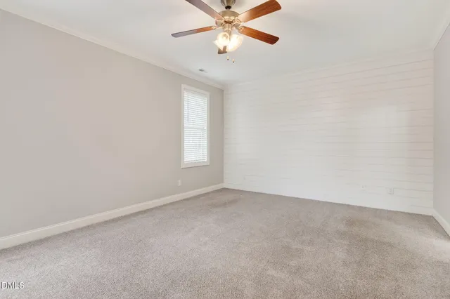 an empty room with closet and a ceiling fan