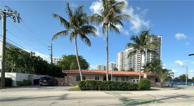 a view of a palm trees front of the house