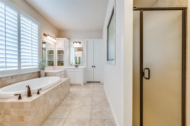a bathroom with a tub a sink and a window