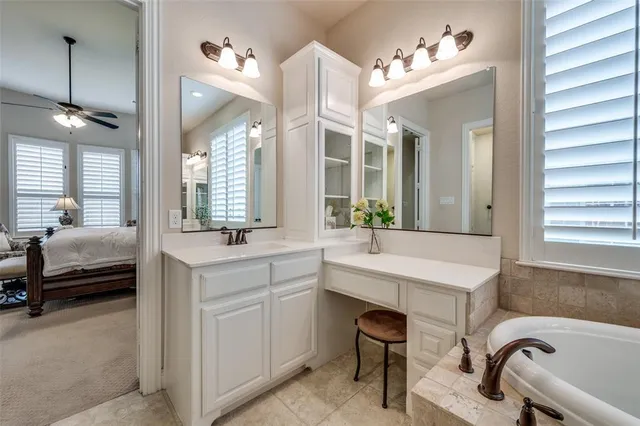 a spacious bathroom with a tub sink and mirror