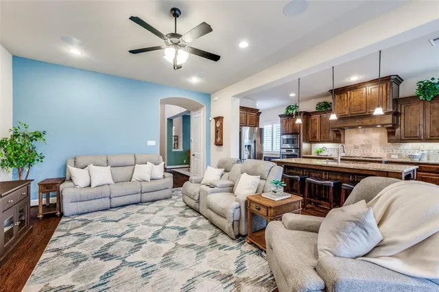 a living room with furniture kitchen view and a chandelier