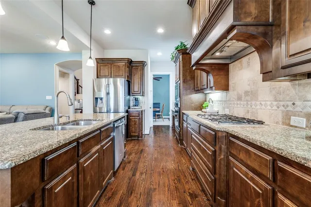 a kitchen with stainless steel appliances granite countertop a stove and a sink