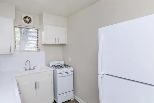 a kitchen with a sink cabinets and a window